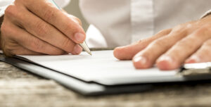 Low,Angle,View,Of,Male,Hand,Signing,Contract,Or,Subscription